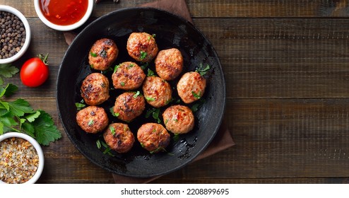 Roasted meatballs in frying pan over wooden background with copy space. Top view, flat lay - Shutterstock ID 2208899695