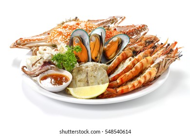 Roasted Mixed Seafood Contain Blue Crabs, Mussels, Big Shrimps, Calamari Squids And Grilled Barracuda Fish Garlic With Spicy Chili Sauce And Lemon On Dish, Isolated On White Background With Shadow.