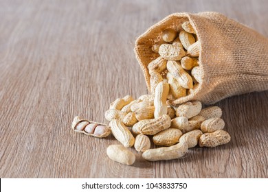 Roasted nuts peanut baked salt with burlap sack on wooden background
