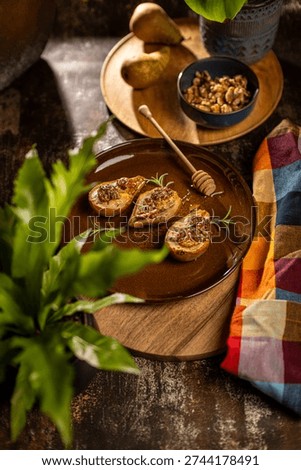 Roasted pears topped with walnuts and blue cheese, autumn seasonal dish with honey drizzle, stylish restaurant plating.