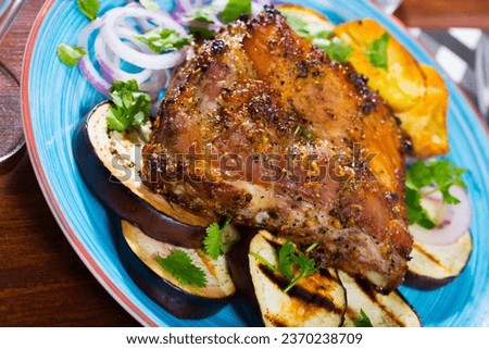 Roasted pork carre served with potato, aubergine and purple onion rings [[stock_photo]] © 