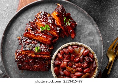 Roasted Pork Ribs in BBQ Sauce with Red Beans in the plate close up. High quality photo