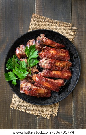 Roasted pork ribs in frying pan, top view.