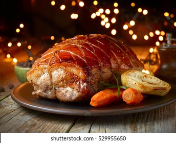 Roasted Pork And Vegetables On Christmas Lights Background