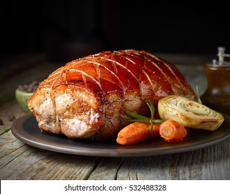 roasted pork and vegetables on dark plate