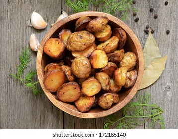 Roasted potato in bowl on wooden table