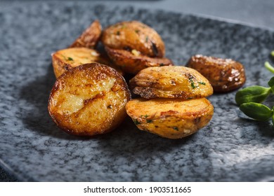 Roasted potato on dark restaurant plate. Vintage gray table. Gourmet food restaurant menu