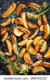 Roasted Potato Wedges With Herbs And Garlic On A Baking Tray