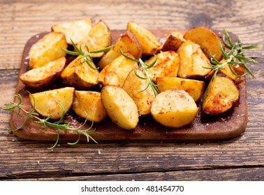 Roasted Potatoes With Rosemary On Wooden Table