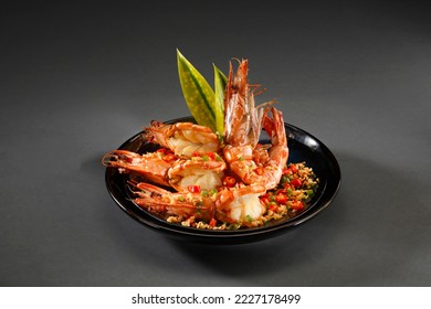 Roasted prawn with chili,garlic and salt in black plate on grey background.