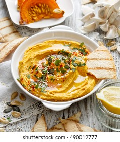 Roasted pumpkin hummus, creamy and delicious dip on a white plate