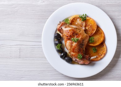 Roasted Rabbit Leg With Oranges, Olives On A White Plate. Horizontal View From Above 