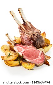 Roasted Rack Of Lamb Chops With Sauteed Wedges Of Rosemary Potatoes Cut Through To Show The Tender Marbled Meat Over White