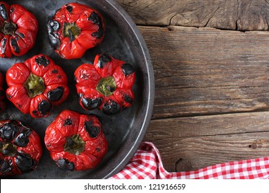 Roasted Red Bell Peppers In A Round Pan, On An Old Wood Board. Rustic Take From Above. Space For Copy.