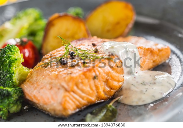 Roasted salmon fillet broccoli tomatoes and fried\
potatoes with dill cream\
sauce.