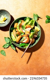 Roasted Salmon And Young Potatoes Salad With Leafy Greens And Lettuce, Top Down View Of The Dish In A Harsh Light