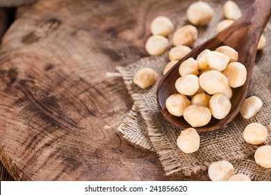 Roasted and salted Macadamia nuts on rustic wooden background