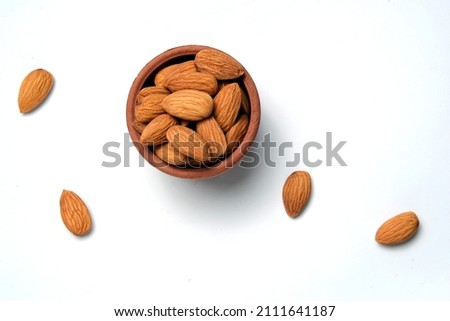 Roasted salted raw cashew nuts in wooden bowl on rustic table, healthy vegetarian snack,Fresh almonds in the wooden bowl, Organic almonds, almonds border white background, Almond nuts on a dark wooden
