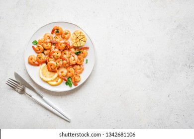 Roasted Shrimps With Lemon, Garlic And Herbs. Seafood, Shelfish. Shrimps Prawns Sauteed With Spices, Garlic And Lemon On White Background, Copy Space. Shrimps Prawns On Plate.