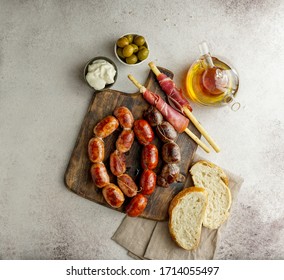 roasted spanish sausages on the cutting board - butifarra blanca, chorizo, morcilla de cebolla, jamon and garlic sause aioli   