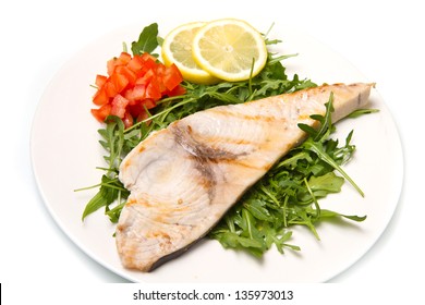 Roasted Swordfish With Lemon, Salad And Tomatoes On White Dish