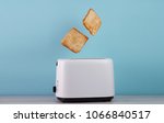 Roasted toast bread popping up of stainless steel toaster on a blue backgroun.Space for text