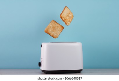 Жареный тост из тостера из нержавеющей стали на синем фоне. Пространство для текста