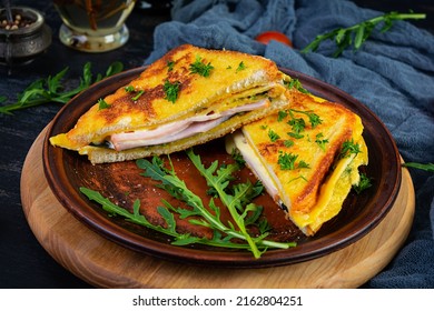 Roasted Toast In Scrambled Eggs With Ham, Herbs And Cheese Cheddar. Delicious Grilled Breakfast Sandwich