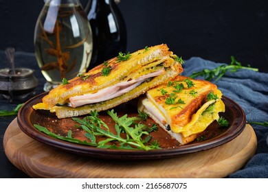 Roasted Toast In Scrambled Eggs With Ham, Herbs And Cheese Cheddar. Delicious Grilled Breakfast Sandwich