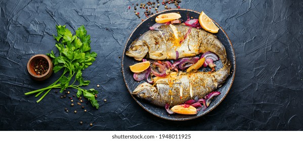 Roasted trout with lemon and onion on plate.Grilled trout - Powered by Shutterstock