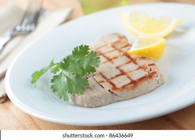 Roasted Tuna Steak On A Plate With Coriander And Lemon