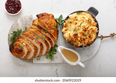 Roasted Turkey Breast Sliced On A Plate For Holiday Dinner With Gravy And Cauliflower Casserole Overhead