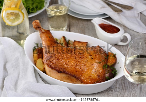Roasted
turkey leg with potatoes on the dinner
table
