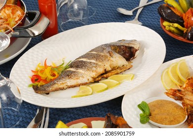 Roasted Whole Fish Seafood Served On White Plate Lemon Slices Capsicum Salt And Pepper Restaurant Table 