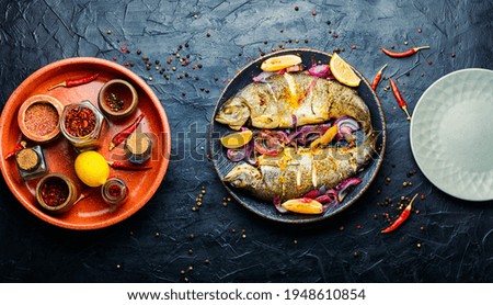 Roasted whole trout with lemon on plate.Delicious fried fish