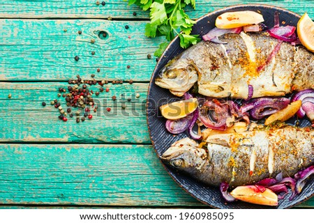 Roasted whole trout with lemon on plate.Space for text
