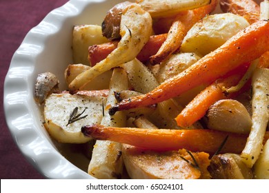 Roasted Winter Vegetables, In Serving Bowl.  Including Carrots, Parsnip, Potato, Butternut Squash, Garlic Bulbs, And Eschallots. Garnished With Rosemary.