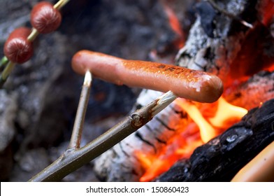 Roasting Hotdogs At The Beach In A Campfire.