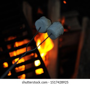 Roasting marshmallows over campfire while camping.