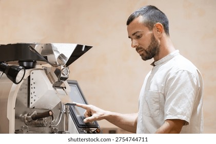Roasting process, worker use Coffee roaster machine for fresh beans.