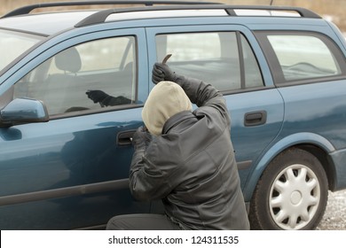 Robber with a crowbar trying to open the car door