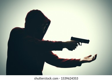 Robber With A Gun.  A Man With A Gun Extorts Money.