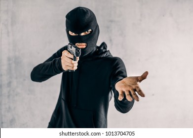 Robber with a gun robbing intimidate.Crime and robbery concept.