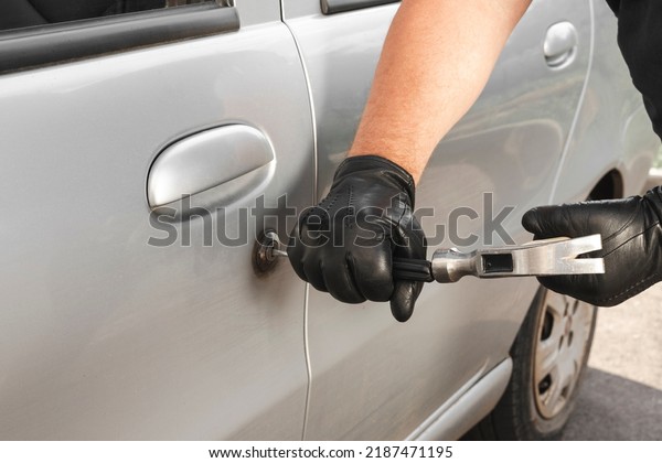 Robber\
with a hammer and a screwdriver opens and knocks out the lock on\
the car door. The concept of robbery or car\
theft.