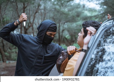 Robber In A Mask Use A Sharp Weapon Want To Kill The Victim When Getting Out Of The Car In The Parking Lot