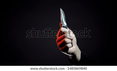 Robber ready to commit crime, threatening victim with knife, camping equipment