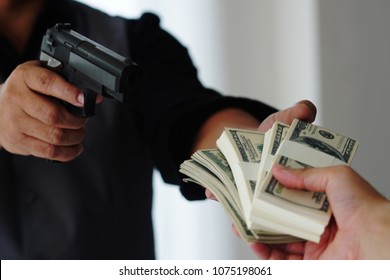 Robbery With Gun's. Gun And Money In A Hands. Bank Robbery, Man Carrying A Gun To Rob The Bank Note. To Threaten With The Man. A Murderer Attacking Holding Gun Kidnapping Business Young Person.