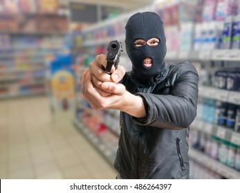 Robbery In Store. Robber Is Aiming And Threatening With Gun In Shop.