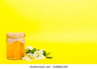 Robinia Honey Bollte With Acacia Blossoms On Colored Table.