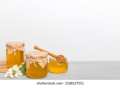 Robinia Honey Bollte With Acacia Blossoms On Colored Table.